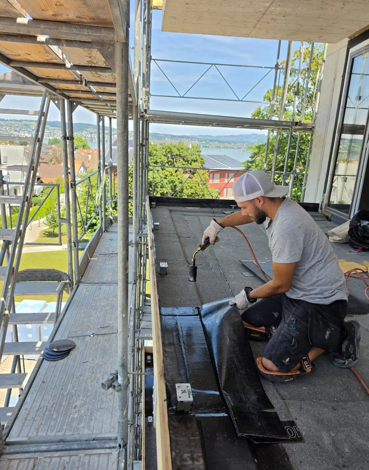 Pedro Mourão beim Verschweissen einer Bitumenbahn auf dem Flachdach